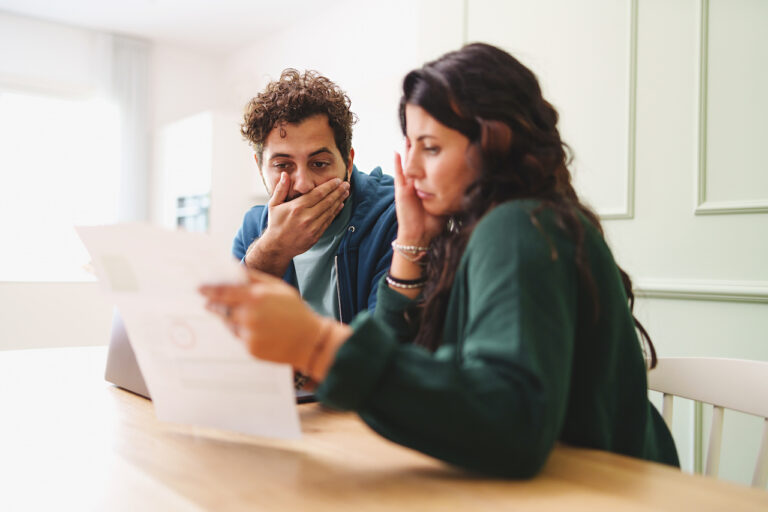 A young married couple is worried looking at their expensive tax bill form the IRS.