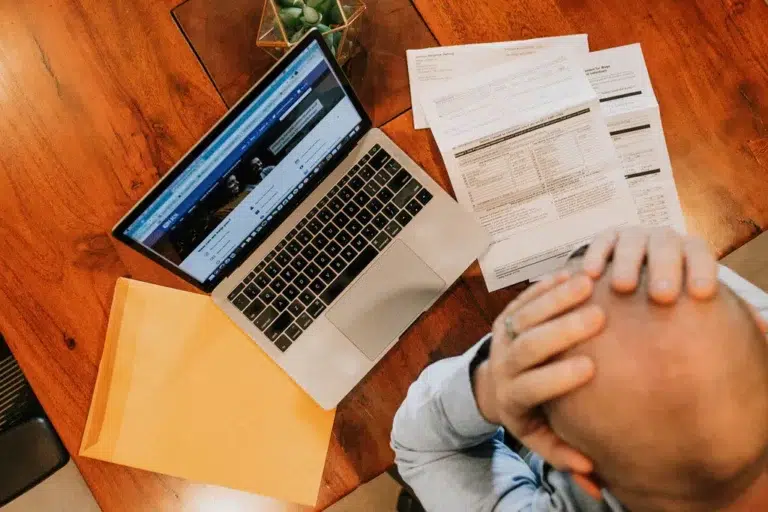 Stressed business owner reviewing IRS tax debt notices, searching for a tax attorney near me in Ohio for debt relief help.